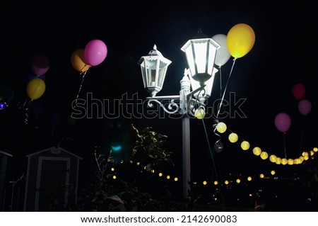 A lamppost with balloons in a party
