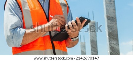 close-up, engineer manager using tablet, building, construction site. inspecting and working at construction site. banner image
