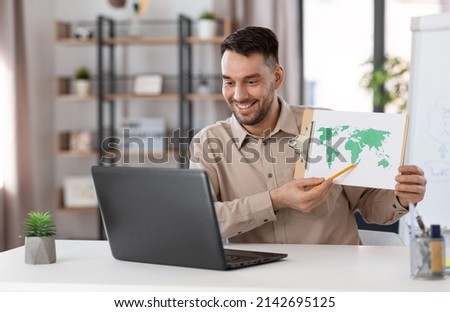 distance education, school and remote job concept - happy smiling male geography teacher with world map and laptop computer having online geography class at home office Royalty-Free Stock Photo #2142695125