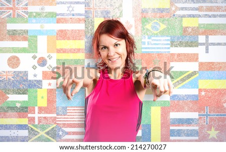 Young girl pointing over flags background 