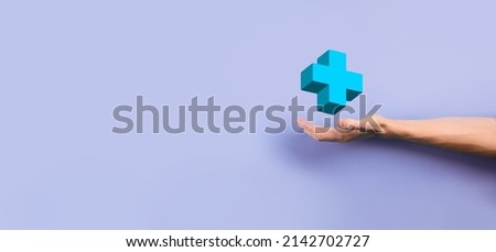 Businessman hold 3D plus icon, man hold in hand offer positive thing such as profit, benefits, development, CSR represented by plus sign.The hand shows the plus sign.