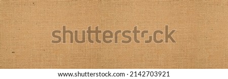 Cotton woven fabric background with flecks of varying colors of beige and brown. with copy space. office desk concept, Hessian sackcloth burlap woven texture background High Resolution ,panoramic Royalty-Free Stock Photo #2142703921