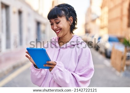 Young woman smiling confident using touchpad at street Royalty-Free Stock Photo #2142722121