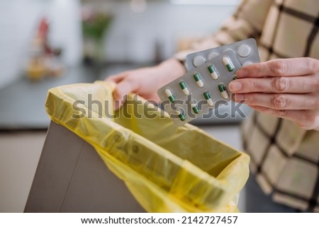 Woman's hands holding and throwing expired pills to the trash bin. Royalty-Free Stock Photo #2142727457