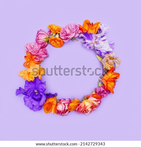Creative layout made of colorful flower buds lying as a round frame on pastel background. Nature concept. Top view. Flat lay
