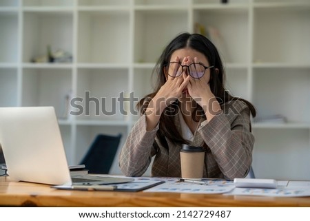tired business woman sleepy and bored from sitting at a desk for a long time and has office syndrome Royalty-Free Stock Photo #2142729487