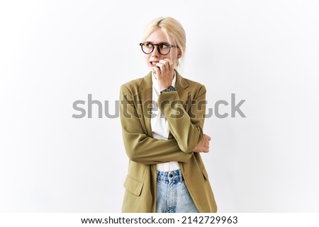 Beautiful caucasian business woman standing over isolated background looking stressed and nervous with hands on mouth biting nails. anxiety problem. 