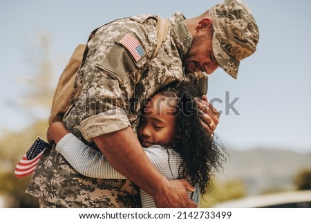 Emotional soldier saying his goodbye to his daughter before going to war. Patriotic serviceman embracing his child before leaving to go serve his country in the military. Royalty-Free Stock Photo #2142733499