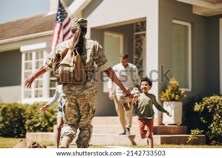 Female soldier reuniting with her family after serving in the army. American servicewoman receiving a warm welcome from her husband and kids. Military woman returning home from deployment. Royalty-Free Stock Photo #2142733503