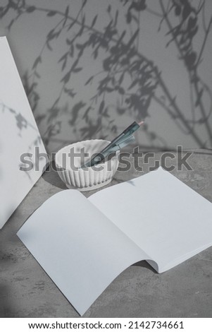 White paper sheets mockup, ceramic vase, books. Minimalist brand identity template. 