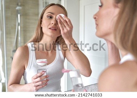 Caucasian woman removing eye make up in the bathroom Royalty-Free Stock Photo #2142741033