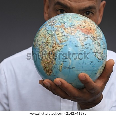 Man holding globe of the world with background stock photo 