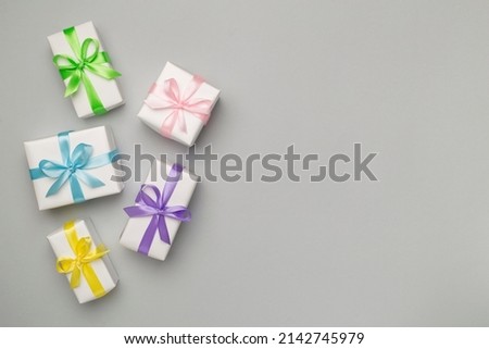 Colorful gift boxes on color background, top view.