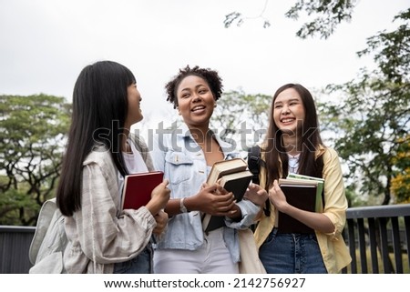 Diversity of happy woman student holding books and looking at natural outdoors at park. Prepare for college and university concept. Informal education and natural research