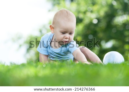 baby sitting on gras