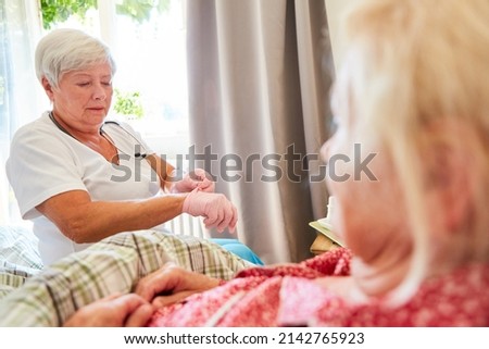 Elderly care worker puts on disposable gloves for home care