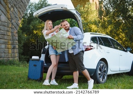 Vacation, Travel - family ready for the travel for summer vacation. suitcases and car route. People with map in hands planning road trip. travel concept. traveler.
