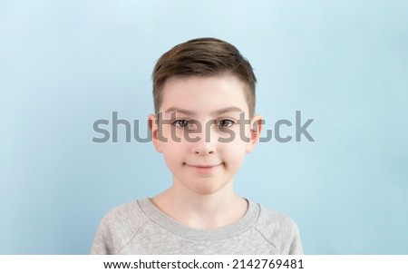 Smiling teenage boy on color background. Photo of adorable young happy boy looking at camera.