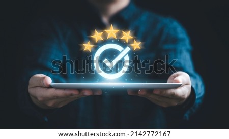 Businessman holding tablet and showing the best quality assurance with golden five stars for guarantee product and ISO service concept. Royalty-Free Stock Photo #2142772167
