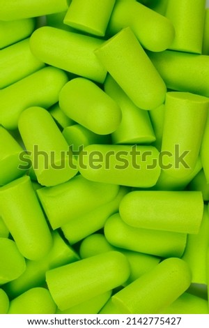 Lots of soft light green foam earplugs. Soft foam ear plugs.Close-up.The concept of getting rid of noise in a noisy place, hearing protection.Vertical photo.High quality photo