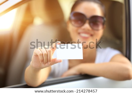 woman driver sit in car hold one blank business card 