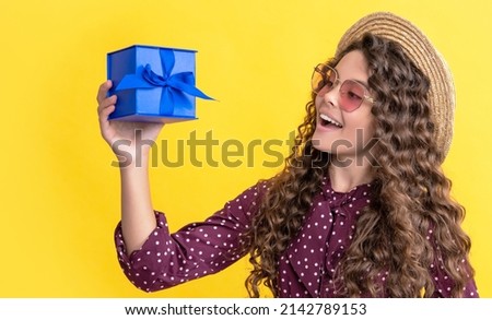 girl smile with curly hair hold present box on yellow background