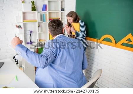 angry teacher shouting at child at blackboard. violence Royalty-Free Stock Photo #2142789195