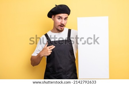 artist man looking shocked and surprised with mouth wide open, pointing to self. copy space concept