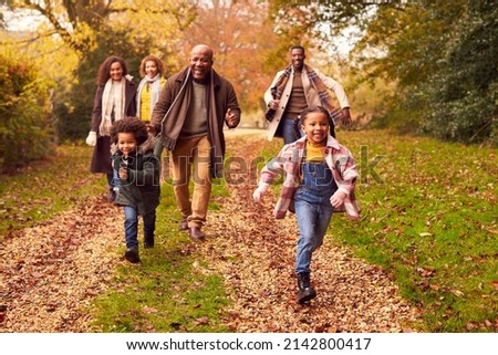 Smiling Multi-Generation Family Having Fun With Children Walking Through Autumn Countryside Together Royalty-Free Stock Photo #2142800417