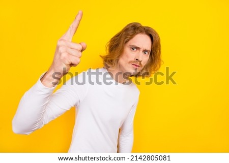 Photo of male with grumpy serious expression point finger empty space promo shopping sale isolated on yellow color background