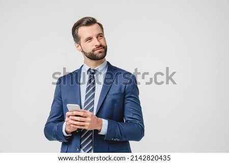 Pensive thoughtful caucasian young businessman ceo boss contemplating using smart phone cellphone for e-banking, e-learning, e-commerce isolated in white Royalty-Free Stock Photo #2142820435
