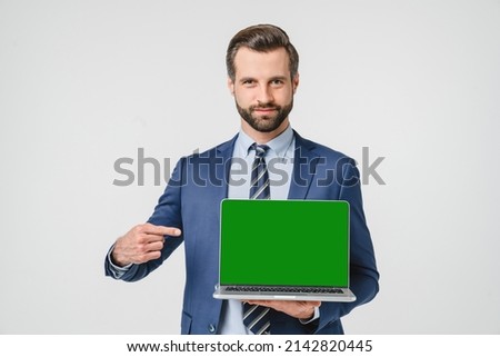 Caucasian young confident businessman pointing showing at computer laptop screen with green mockup copyspace for e-learning, remote work, application online isolated in white background Royalty-Free Stock Photo #2142820445