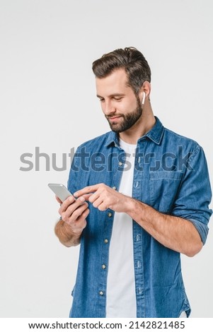 Vertical portrait of caucasian young man student freelancer listening to the music in headphones, choosing sound track, podcast radio station isolated in white background