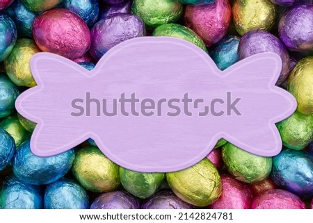 Blank pale purple banner with colorful shiny Easter eggs candy for your Easter or candy message