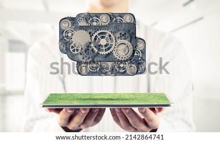 Metal gears and cogwheels mechanism or engine on white office background. Mixed media