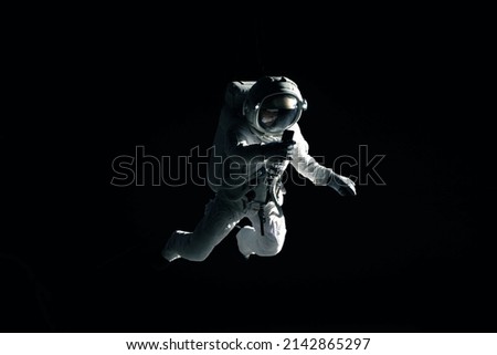 Caucasian female astronaut using her mobile phone during spacewalk, messaging, taking pictures Royalty-Free Stock Photo #2142865297