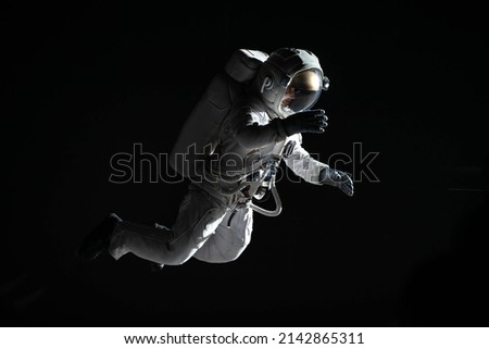 Full portrait of Caucasian female astronaut during spacewalk, black deep space background Royalty-Free Stock Photo #2142865311