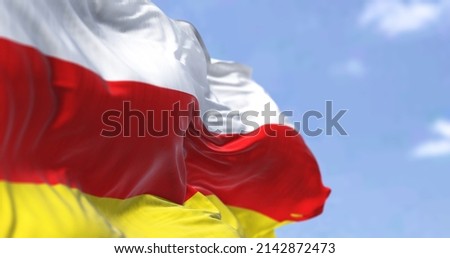 Detail of the national flag of South Ossetia waving in the wind on a clear day. South Ossetia is a breakaway state in the South Caucasus. Selective focus. Royalty-Free Stock Photo #2142872473