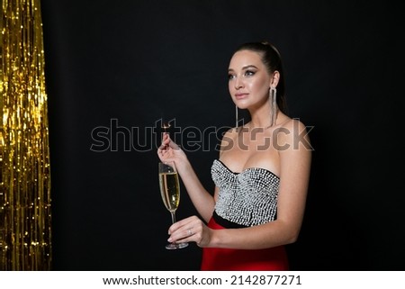 woman at a holiday party with a glass of champagne and a sparkler
