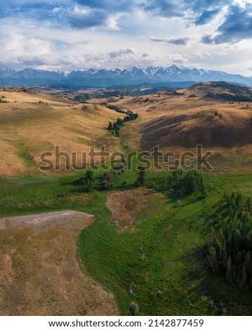 Kurai steppe and Chuya river on North-Chui ridge mountains background. Altai mountains, Russia. Aerial drone panoramic picture.