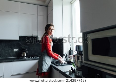 woman cooks in the kitchen to clean dishes