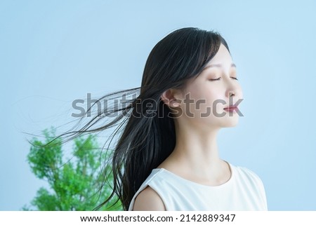 Young woman with fluttering hair and a smile Royalty-Free Stock Photo #2142889347