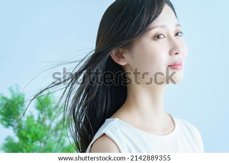 Young woman with fluttering hair and a smile Royalty-Free Stock Photo #2142889355