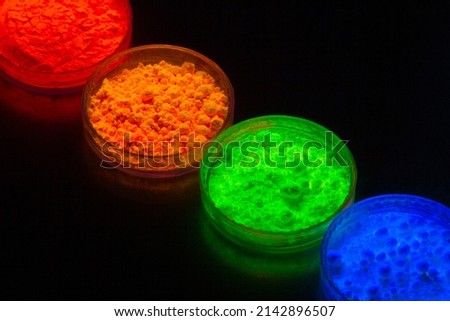 top view of neon colorful traditional holi powder in bowls isolated on dark background.Space for text . happy holi.