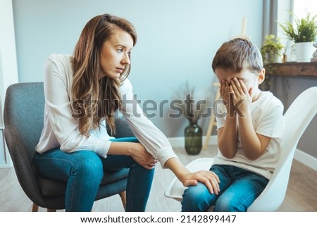 Parenthood and child development, young worried mother comforting little son crying at home. Worried mother comforting crying son. Young boy having therapy with a child psychologist Royalty-Free Stock Photo #2142899447