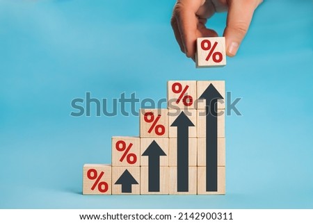 Wooden blocks with percentage sign and arrow up, financial growth, interest rate increase, inflation concept. Concept of interest financial and mortgage rates