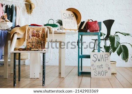 swap party for try on clothes, bags, shoes and accessories, friends change clothes, second hand and zero waste life, eco-friendly approach to consumption, clothes hanger in loft interior Royalty-Free Stock Photo #2142903369