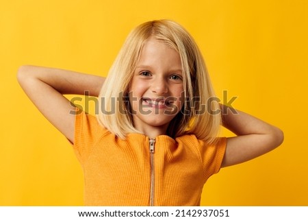 kid girl in a yellow t-shirt smile posing studio isolated background unaltered