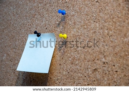 Empty note on corkboard with bulletin pins. 