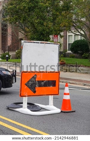 Blank white information road sign on top of an orange detour sign with a black arrow